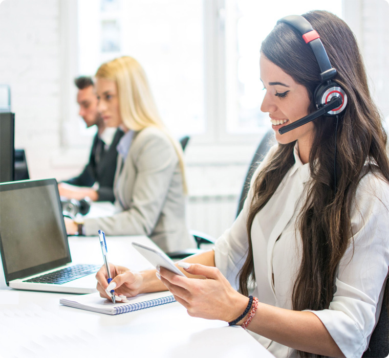 Woman working on phone support while taking notes